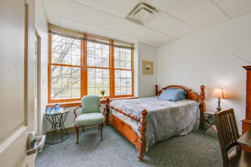 a bedroom with a bed and a chair and windows at Work, Play & Explore: 9-Unit New Kensington Base in New Kensington