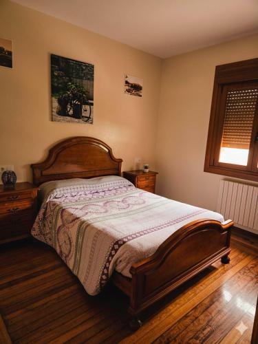 a bedroom with a large bed with a wooden headboard at A Veiga Grande in Pontevedra