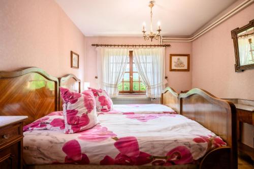 a bedroom with a bed with pink pillows at Gîte Éclat De Soleil in Beblenheim