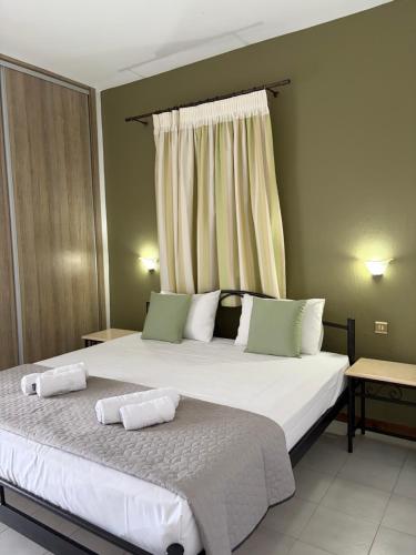 a bedroom with a large bed with two pillows at Yannis Apartments in Afitos