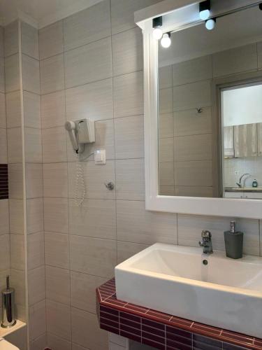 a bathroom with a sink and a mirror at Yannis Apartments in Afitos