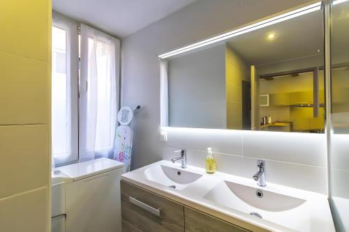 a bathroom with two sinks and a large mirror at La Curiosité in Barr