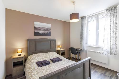 a bedroom with a bed with two towels on it at La Curiosité in Barr
