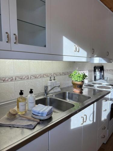 a kitchen with white cabinets and a sink at Levrasjön Lake House Private Pier in Bromölla