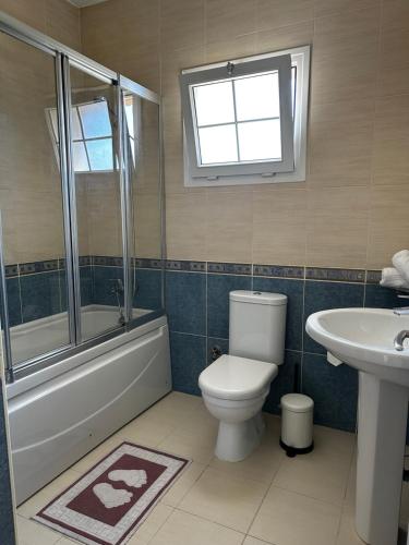 a bathroom with a toilet and a tub and a sink at Hillside Villa with Sea Views in Kyrenia