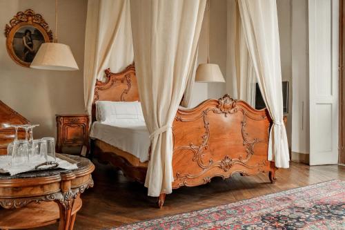 a bedroom with a wooden bed with a canopy at Villa Wirnica Lake Como in Garlate