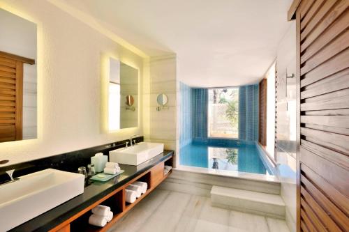 a bathroom with a sink and a swimming pool at The Westin Pushkar Resort & Spa in Pushkar