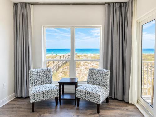 a room with two chairs and a table and a window at Perdido Key Beachfront 4BR Sleeps 12 Steps to the Beach Sweeping Gulf View in Pensacola