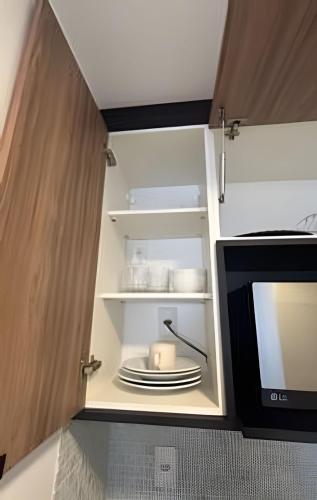 a cupboard with a microwave and a plate in it at Studio 810 | Completo e Novo | SP Expo e Congonhas in São Paulo