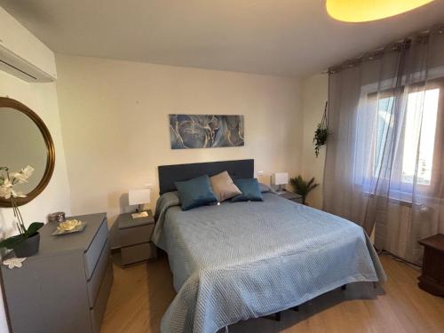 a bedroom with a blue bed and a mirror at Vicolo dell'Orto in Montaione