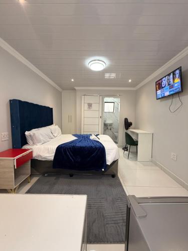 a bedroom with a bed and a tv on the wall at The Perfect Place in Parow