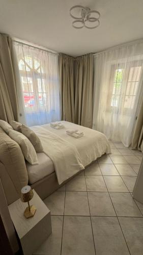 a bedroom with a bed with white sheets and windows at Terra intelvi in San Fedele Intelvi