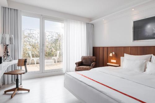 a bedroom with a bed and a chair and a window at Ruby Sofie Hotel Vienna by IHG in Vienna