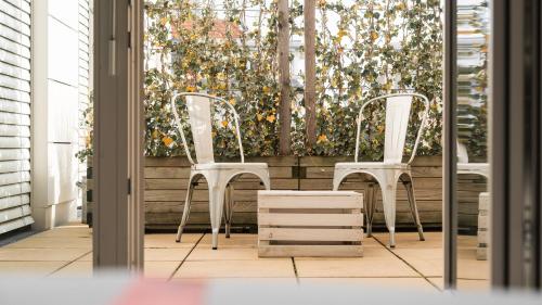 two white chairs sitting in front of a window at Ruby Sofie Hotel Vienna by IHG in Vienna