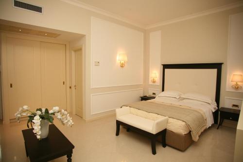 a bedroom with a bed and a chair and a table at Hotel Miramare & Spa in Sestri Levante