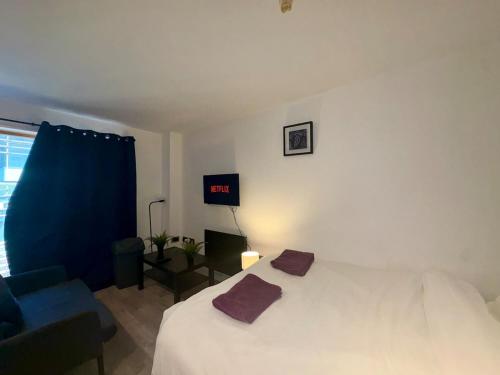a bedroom with a white bed and a blue chair at Central Sheffield Studio for 2 in Sheffield