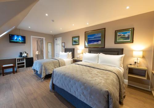 a hotel room with two beds and a desk at The Tides Ballybunion in Ballybunion