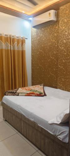 a bed in a room with a curtain at OM DAYAMA Please in Khātu