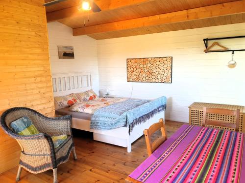 a bedroom with a bed and a chair in a room at Die blaue Hütte - Tiny House am Elberadweg in Seestermühe