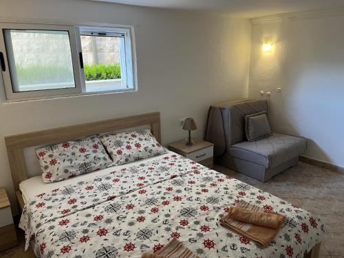 a bedroom with a bed and a chair and a window at Villa Milovic, appartements les pieds dans l'eau! in Radovici