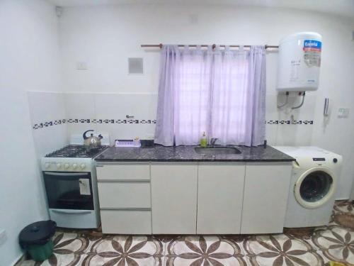 a kitchen with a sink and a washing machine at Depto Manzur in Villa Mercedes