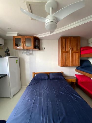 a bedroom with a blue bed and a ceiling fan at Antigo hotel murubira in Belém