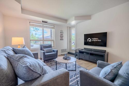 a living room with a couch and a tv at The Beach Point - Ground Floor BBQ in Invermere