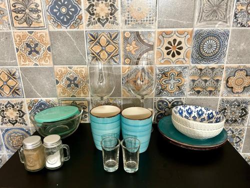 a table with bowls and glasses on a tiled wall at Estudio #4 a 5 min del malecon in La Paz
