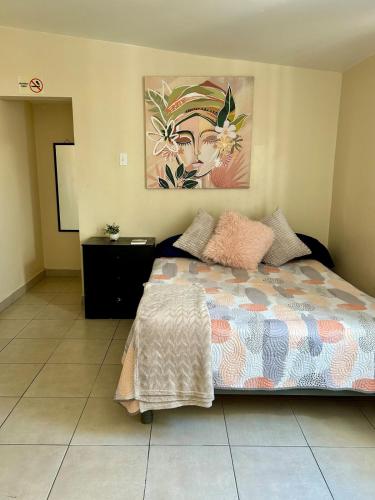 a bedroom with a bed and a painting on the wall at Estudio #4 a 5 min del malecon in La Paz