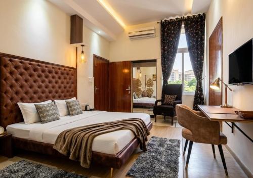 a hotel room with a bed and a desk at Giovanni Suites in Bhopal