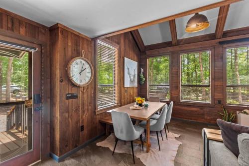 a dining room with a table and a clock on the wall at Jackson’s Urban Cabin Escape in Jackson
