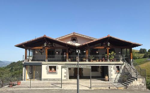 a large house with a balcony on a hill at Izarra Urdaneta in Aizarna