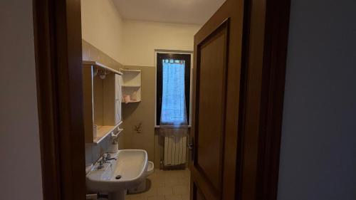 a bathroom with a sink and a toilet and a window at Casa Irene in Marina di Massa