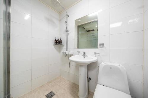 a white bathroom with a sink and a toilet at 호텔 휴 in Pup'yŏng-yŏk