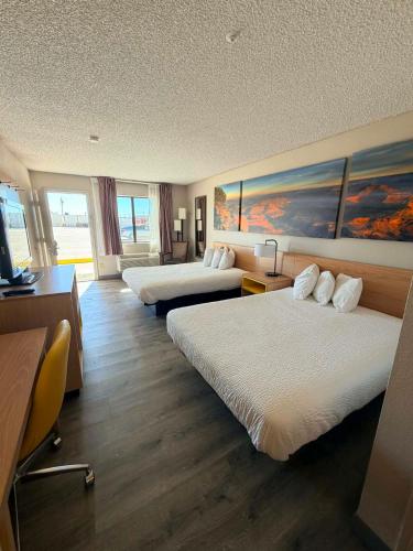a hotel room with two beds and a desk at Days Inn by Wyndham Kingman West in Kingman