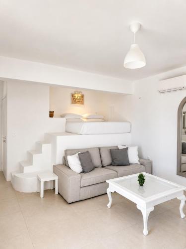 a white living room with a couch and a bed at Aphrodite's Villa in Ambelas