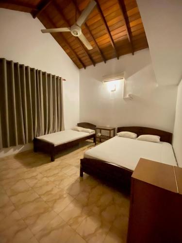 a bedroom with two beds in a room with curtains at CFR SkyLine in Katunayaka