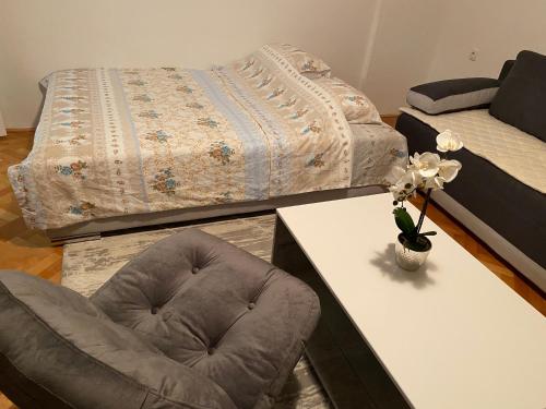 a bedroom with a bed and a chair and a table at Sladjana apartman in Prijepolje
