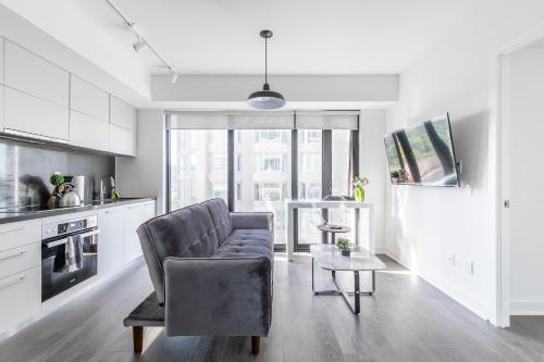 a living room with a couch and a table at The Nobleton Suites - Yorkville in Toronto