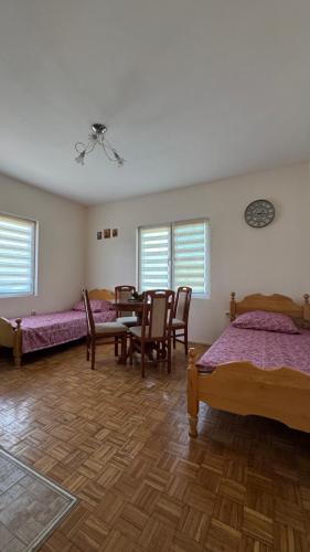 a room with four beds and a table and chairs at Perućac - Apartman sa pogledom na jezero in Perućac