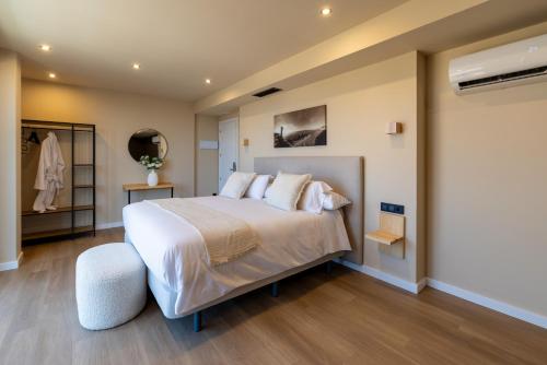 a bedroom with a large white bed and a closet at Arena Málaga Suites in Málaga