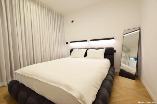 a bedroom with a large white bed and a mirror at Ville delle luci in Tefahot
