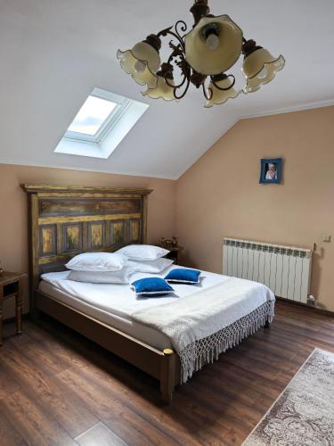 ein Schlafzimmer mit einem großen Bett und einem Kronleuchter in der Unterkunft Luisenthal Conac Boutique Retreat & Spa Bucovina in Fundu Moldovei