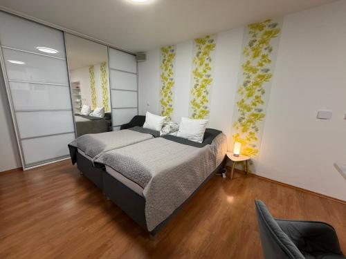 a bedroom with a bed and a chair in it at Apartment Komin in Komín