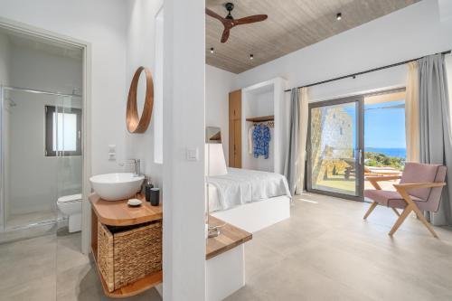 a bedroom with a bed and a bathroom with a sink at Gray and Blue in Andros