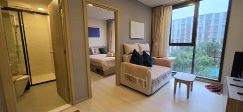 a bedroom with a bed and a chair in a room at The Rock Condo Central Phuket "Min-1 week" in Ban Rangeng