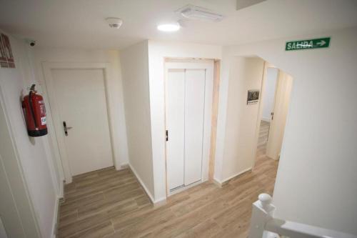 a hallway with two doors and a fire extinguisher at Apartamentos Canto Encaramado in Gibaja