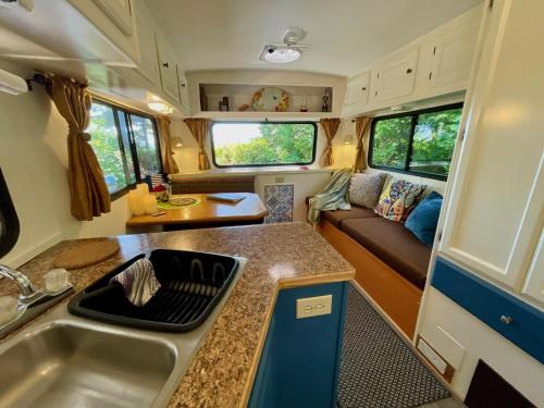 a kitchen and living room in a rv at So Damn Lucky Glamping in Ucluelet