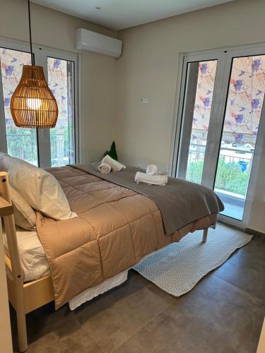 a bedroom with a bed with two towels on it at Kyma Boutique Suite in Nea Makri