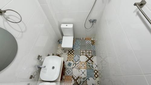 a small bathroom with a toilet and a tile floor at Chalet Kvariati in Kvariat'i